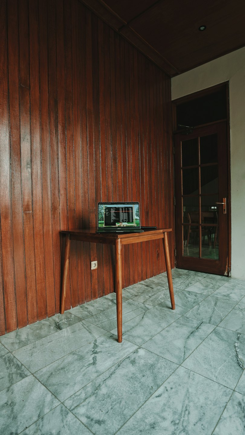 Informazioni Un laptop aperto con codice visualizzato è appoggiato su un tavolo di legno.