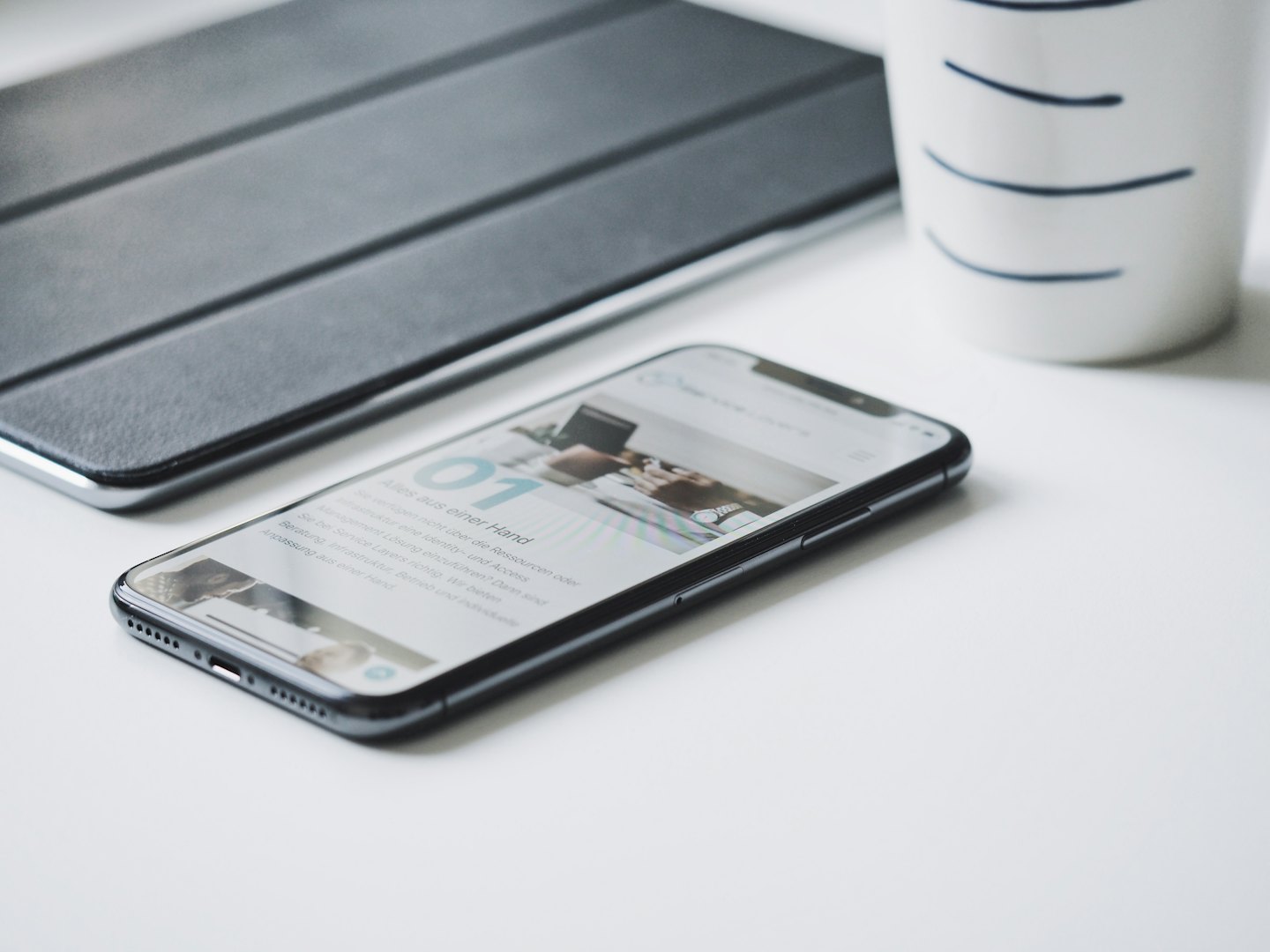 Home Custodia nera per smartphone e tablet su una scrivania bianca.